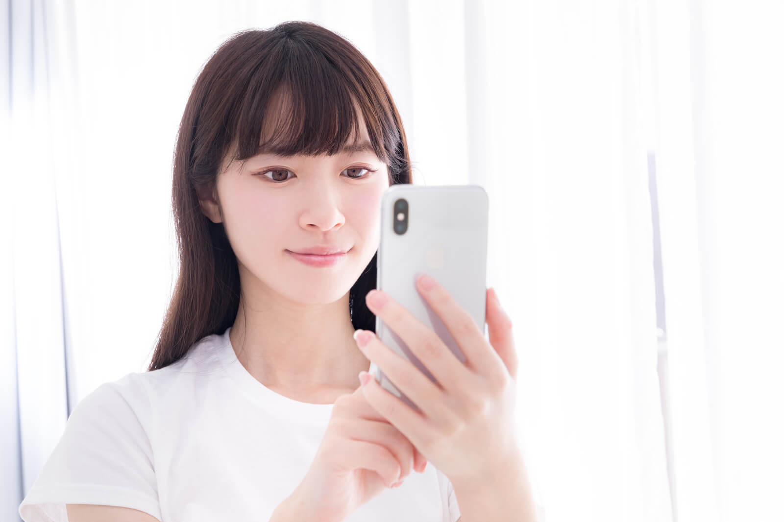 スマホで個人輸入代行サイトを閲覧する女性のイメージ画像